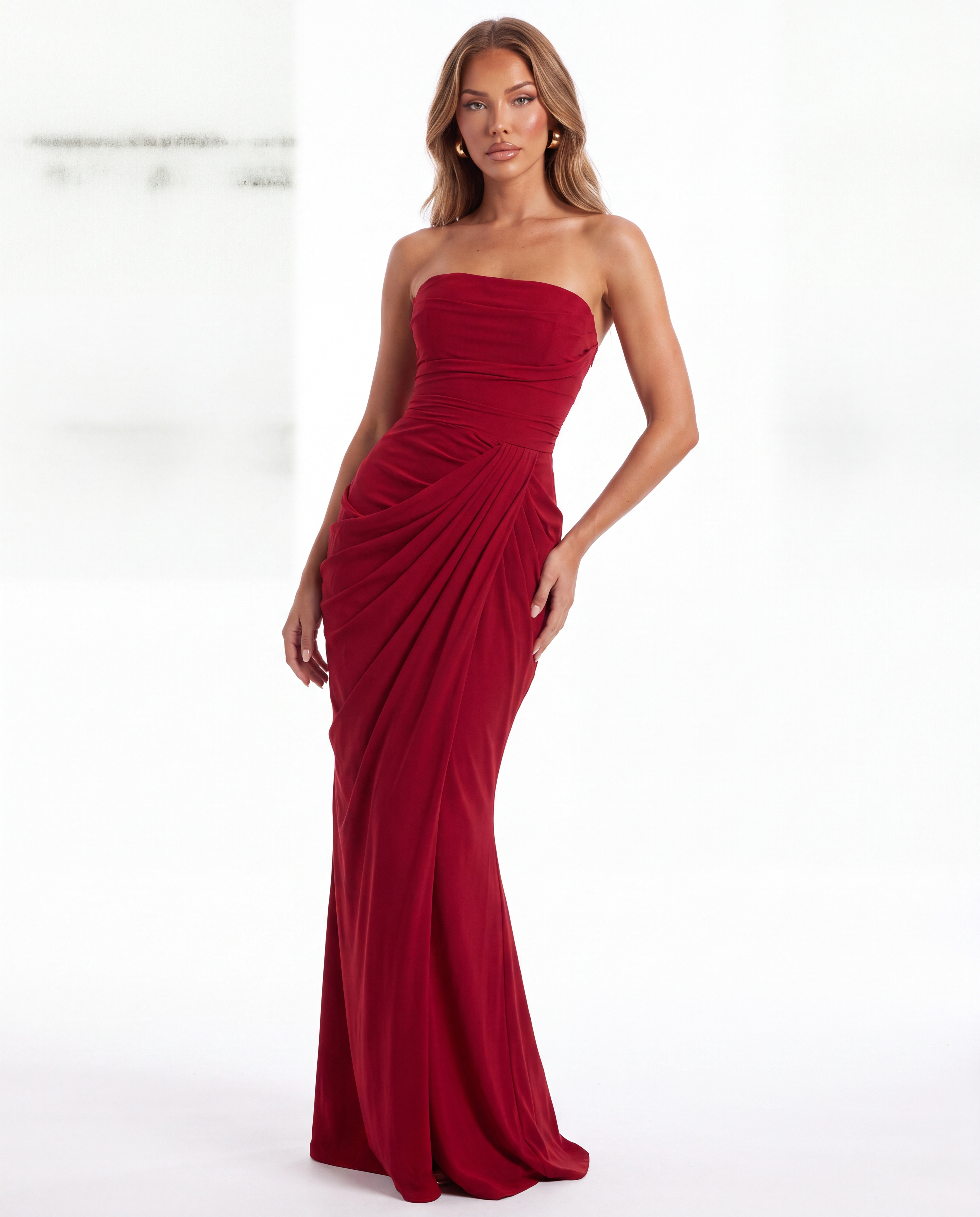 Model wearing a red strapless draped evening gown